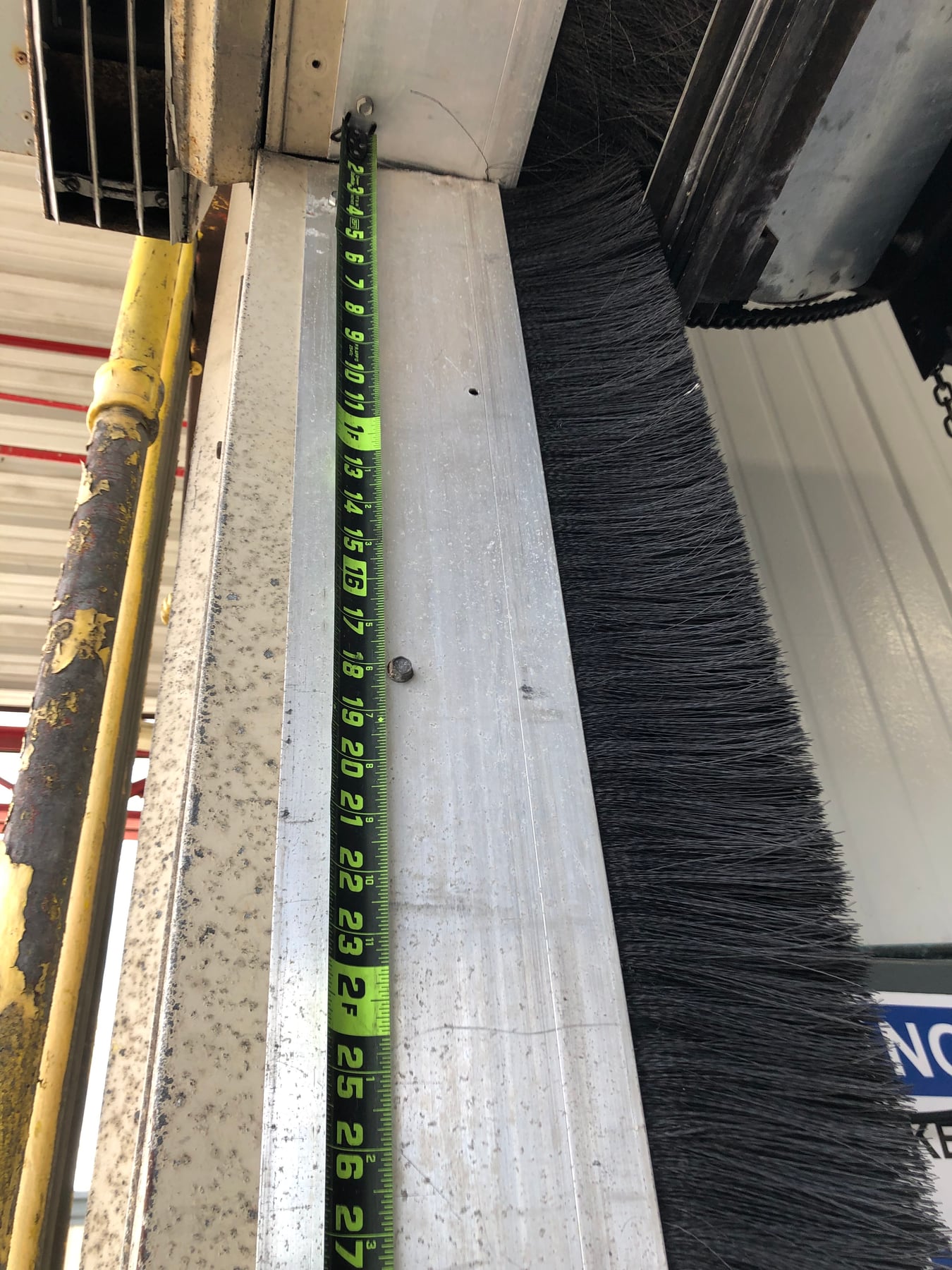 Brush sealing material beside a commercial door frame