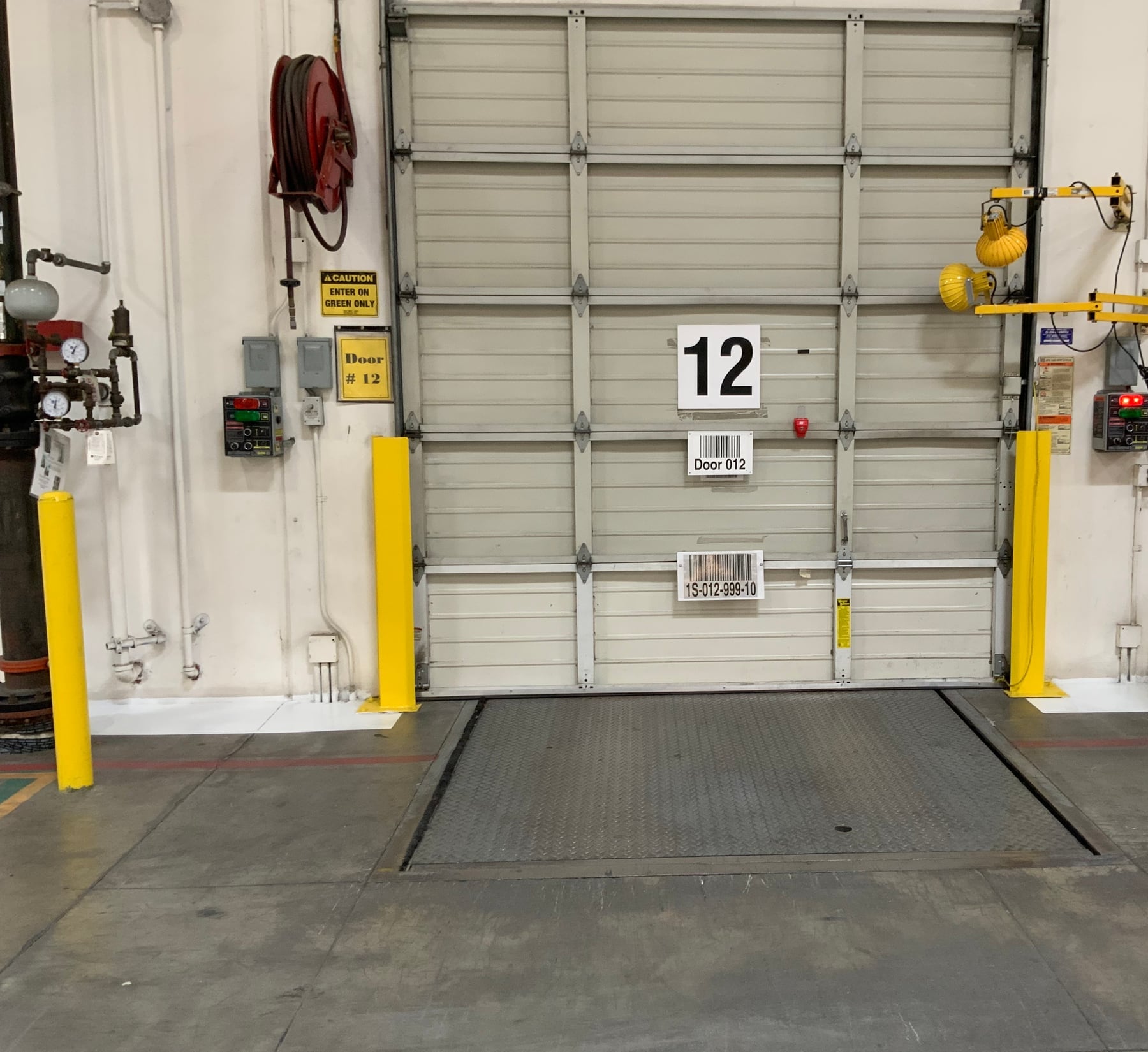 Closed loading dock door and leveler inside a warehouse being reviewed for audit preparation