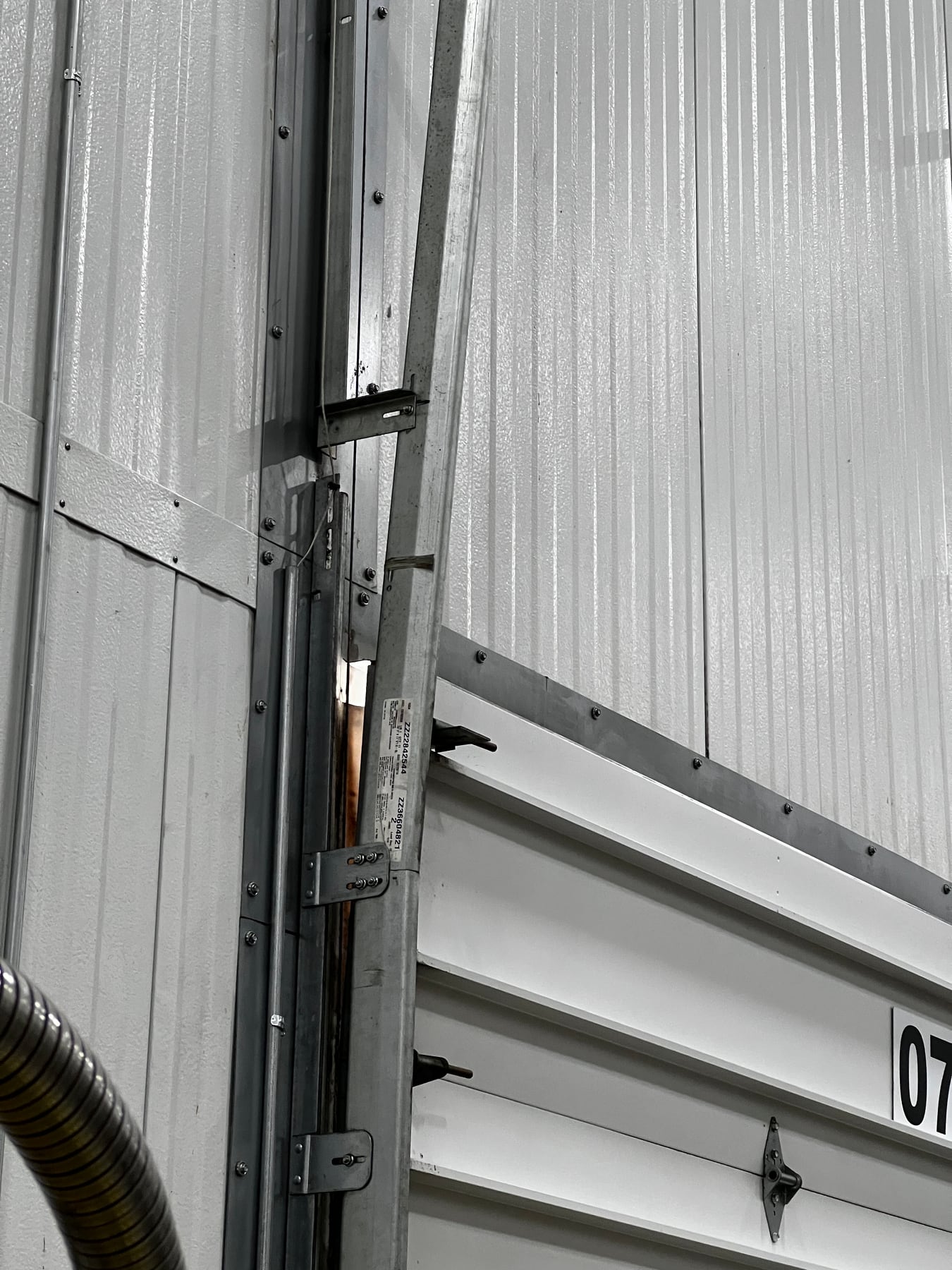 Visible opening along the edge of a closed commercial overhead door