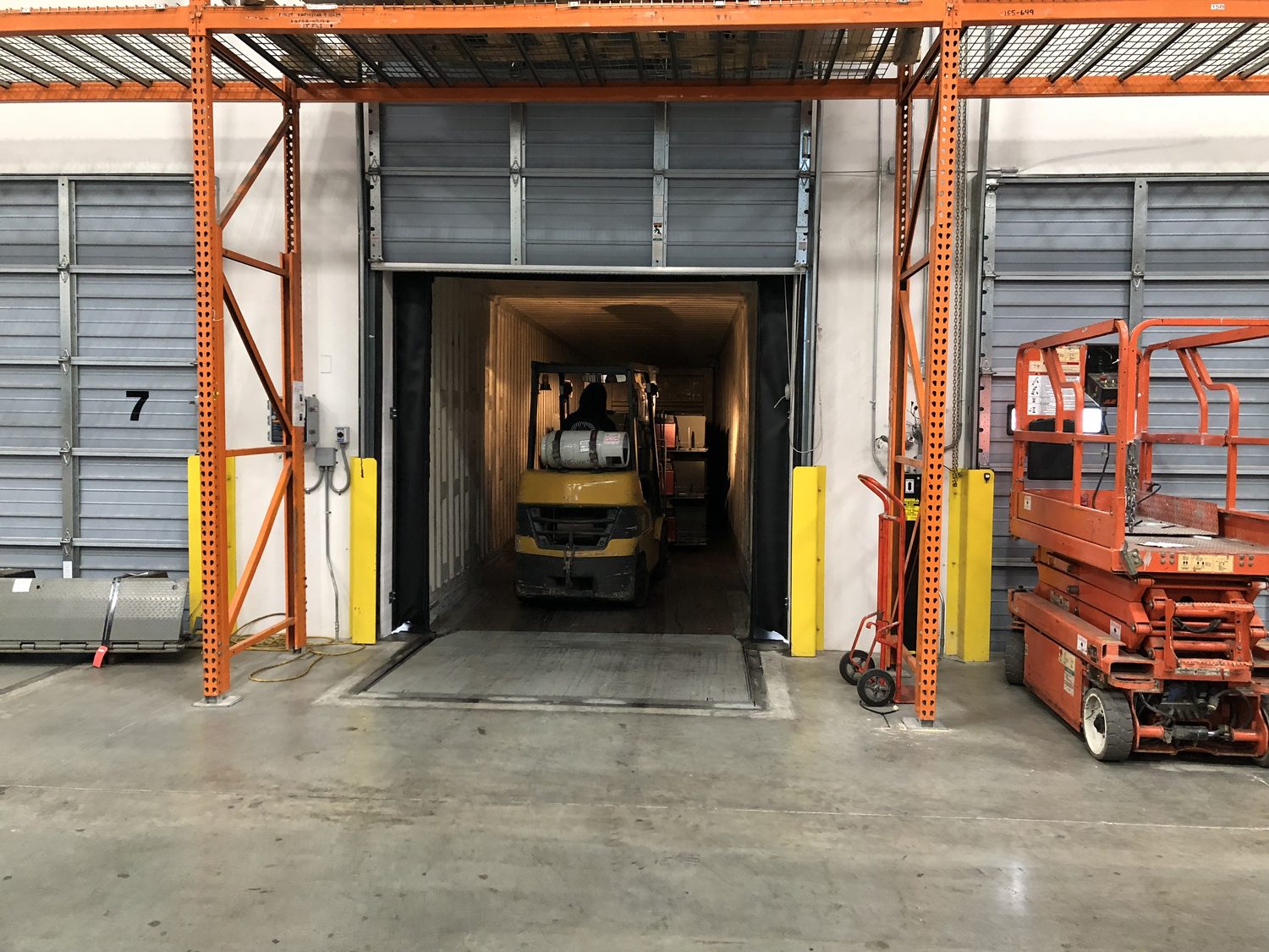 Forklift moving through a commercial overhead door bay